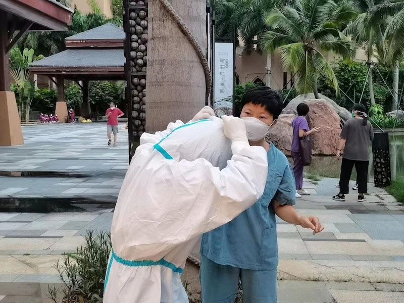 張翔幫助同事整理防護(hù)服。受訪者供圖