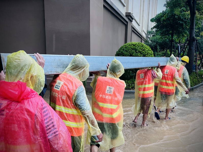 建設(shè)者們冒雨施工。梁惠攝