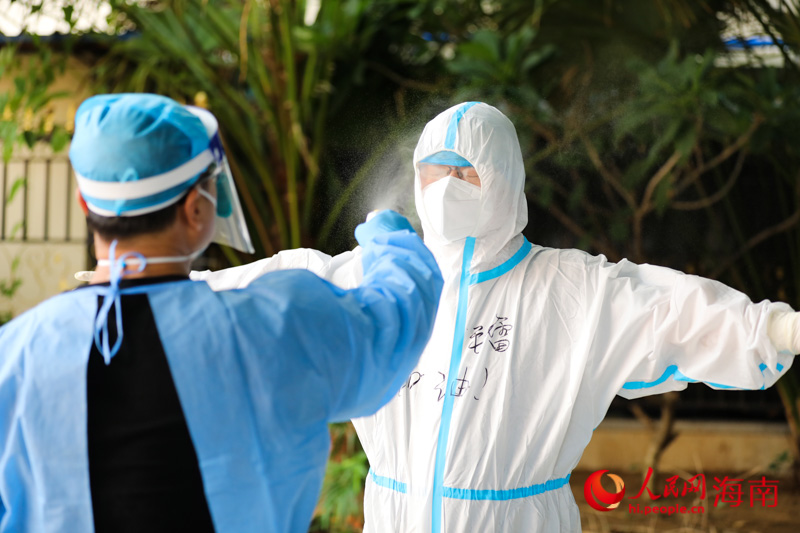 協(xié)助醫(yī)護人員做核酸后，記者對全身進行消殺。人民網(wǎng) 符武平攝