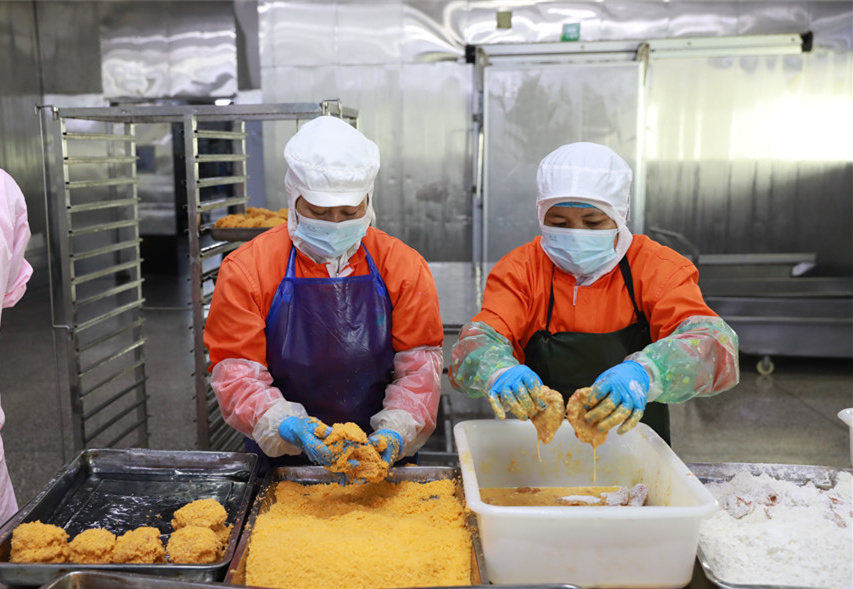 海南力合泰食品有限公司車間內(nèi)，工作人員各司其職，有條不紊地工作著。