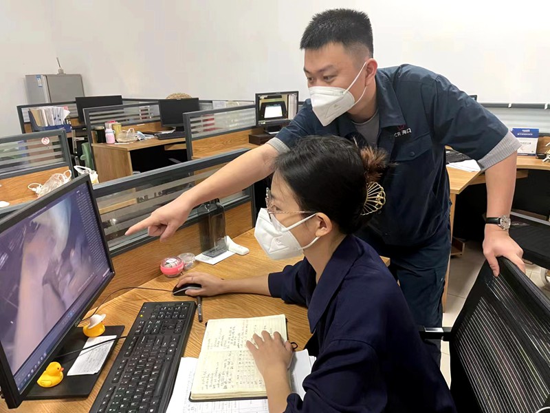 李鑰和田微對班組作業(yè)人員攝錄視頻問題進行分析探討。任偉軍攝