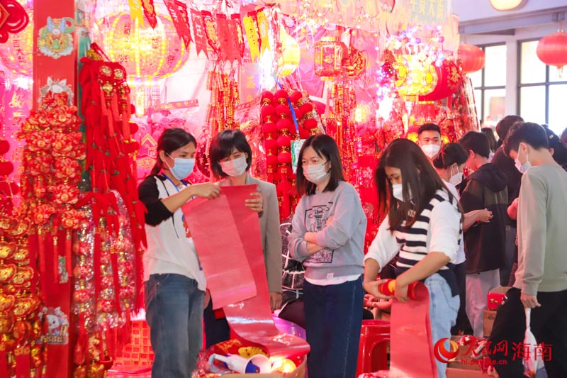夜市增設(shè)了“年貨大街”，市民在選購(gòu)對(duì)聯(lián)。人民網(wǎng) 牛良玉攝