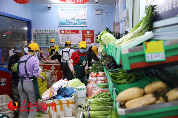 在海口市菜籃子平價(jià)超市，員工將運(yùn)進(jìn)來的蔬菜歸類整理。人民網(wǎng) 孟凡盛攝