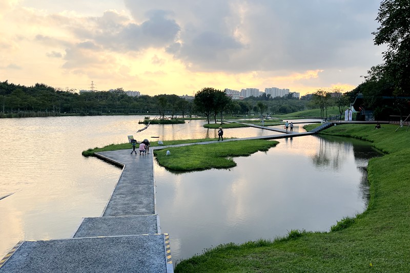 海口瓊山區(qū)美舍河鳳翔濕地公園一隅，市民在親水步道享受落日余暉下的天光水色。