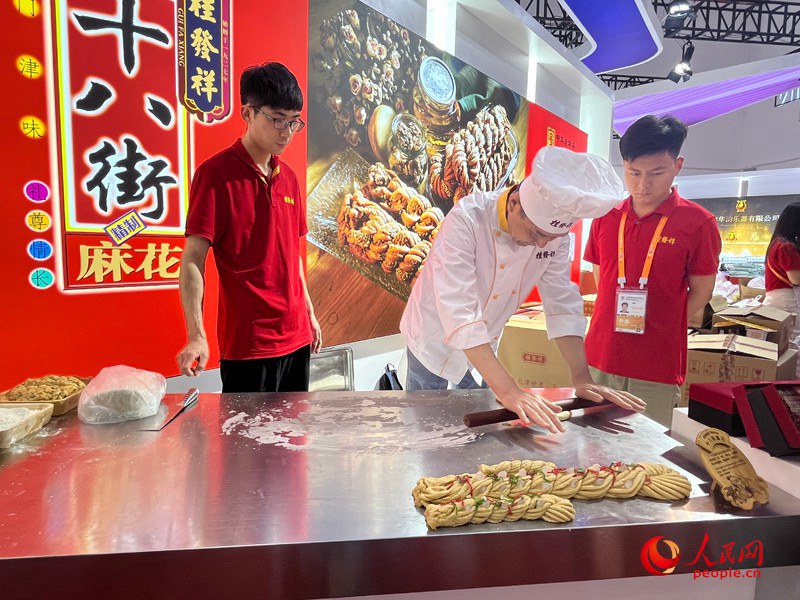 國家級非物質(zhì)文化遺產(chǎn)麻花制作技藝亮相消博會。人民網(wǎng)記者 杜燕飛攝