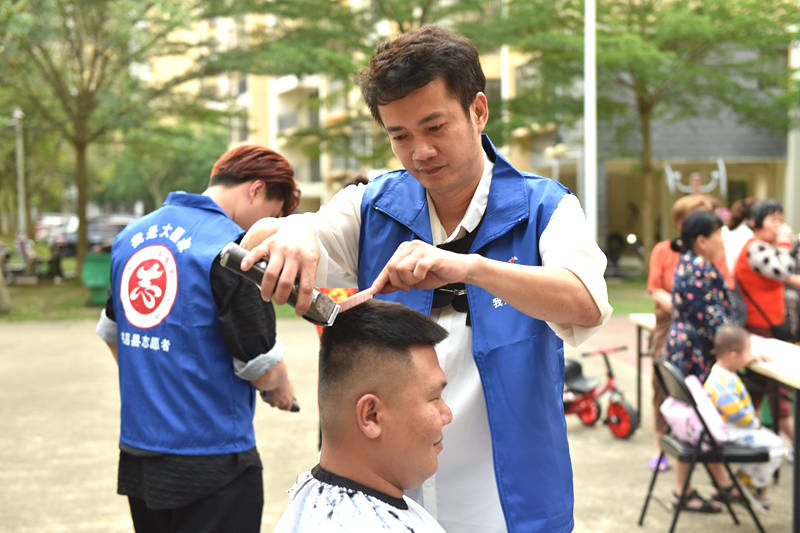 志愿者為市民剪頭發(fā)。 林小丹攝