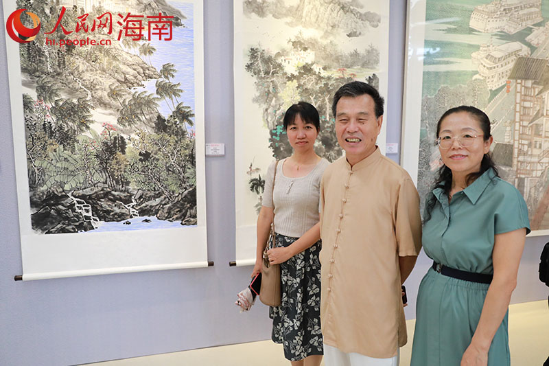 畫家陳兆堤（左二）與他的作品《黎家春風(fēng)》。人民網(wǎng) 孟凡盛攝