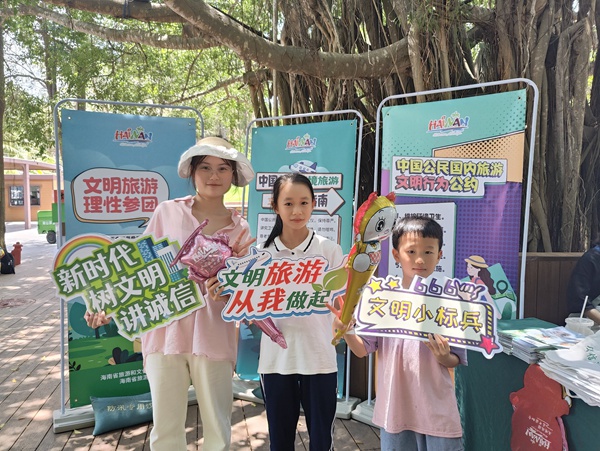 游客手拿文明旅游標識牌打卡。海南省旅游協(xié)會供圖