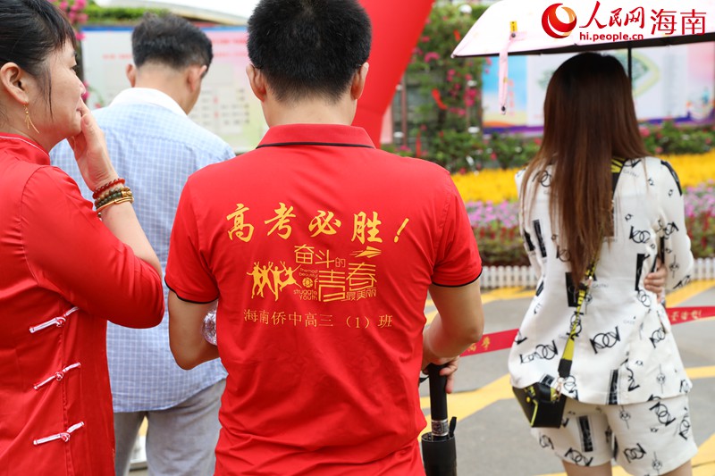 在海南華僑中學(xué)（高中部）考點(diǎn)，不少家長(zhǎng)穿著紅色衣服前來為考生加油。人民網(wǎng)記者 孟凡盛攝