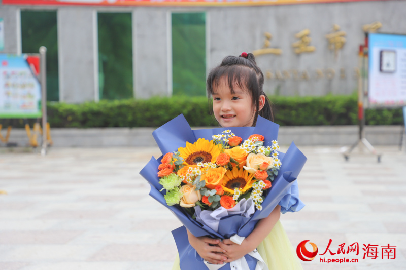 小朋友手捧鮮花，等待著姐姐走出考場(chǎng)。人民網(wǎng) 牛良玉攝
