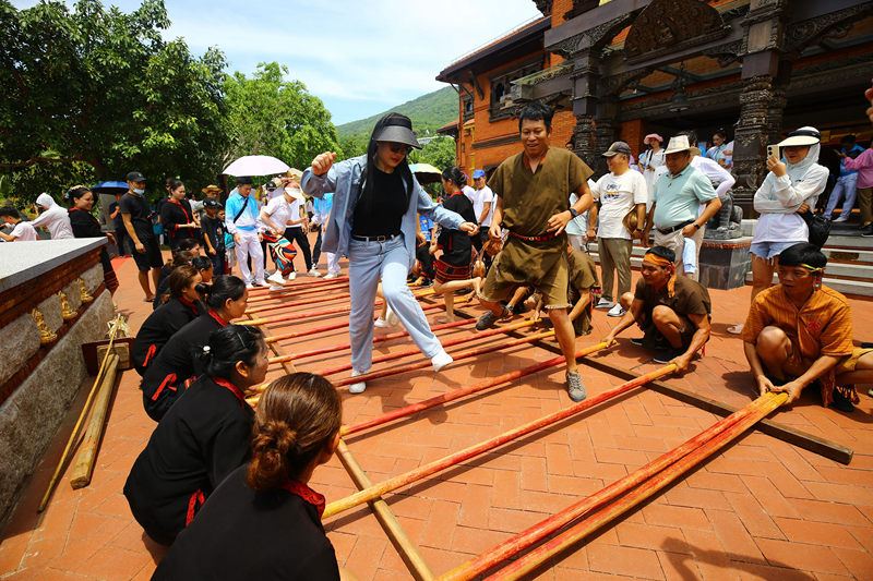 6月10日，三亞南山非遺節(jié)現(xiàn)場，游客體驗國家非遺項目《打柴舞》。陳文武攝