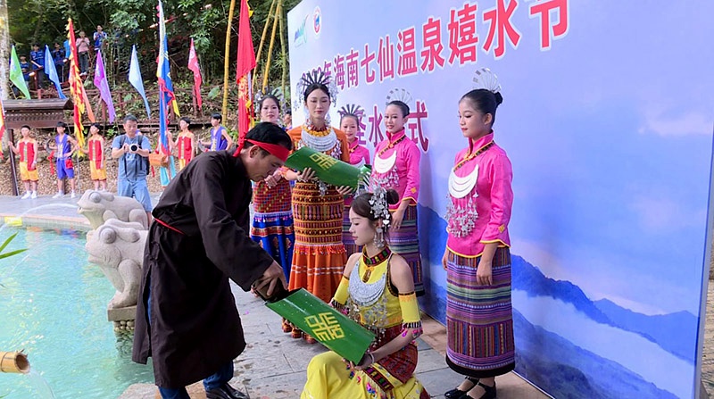 “長老”從圣水潭中舀起象征吉祥如意的“圣水”裝滿竹筒。保亭縣委宣傳部供圖
