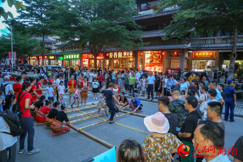 現(xiàn)場竹竿舞表演吸引眾多市民游客圍觀。人民網(wǎng) 牛良玉攝