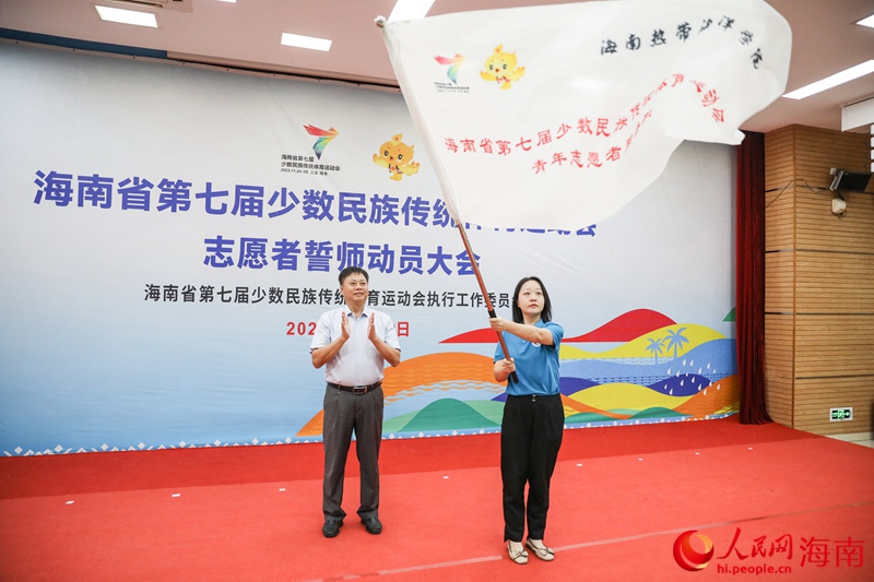 圖：張長豐為海南熱帶海洋學(xué)院志愿者服務(wù)隊(duì)授旗。人民網(wǎng)記者 牛良玉攝