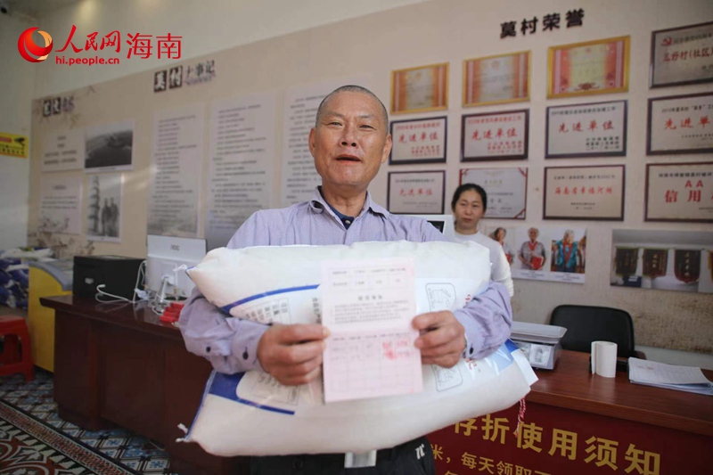 莫村村民高興地領(lǐng)取大米。人民網(wǎng)記者 李學(xué)山攝