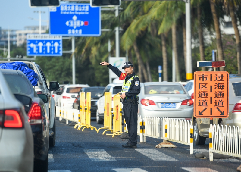 ?？谑袨I海大道交警正在指引過海車輛有序通行前往新海港碼頭。石中華攝