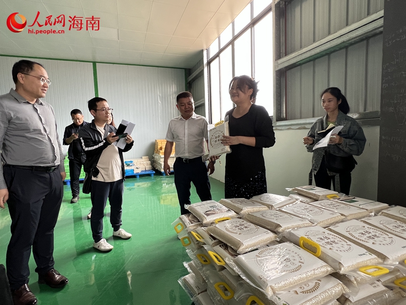 王婷（右二）介紹公坡香米種植和加工情況。人民網(wǎng)記者 李學(xué)山攝