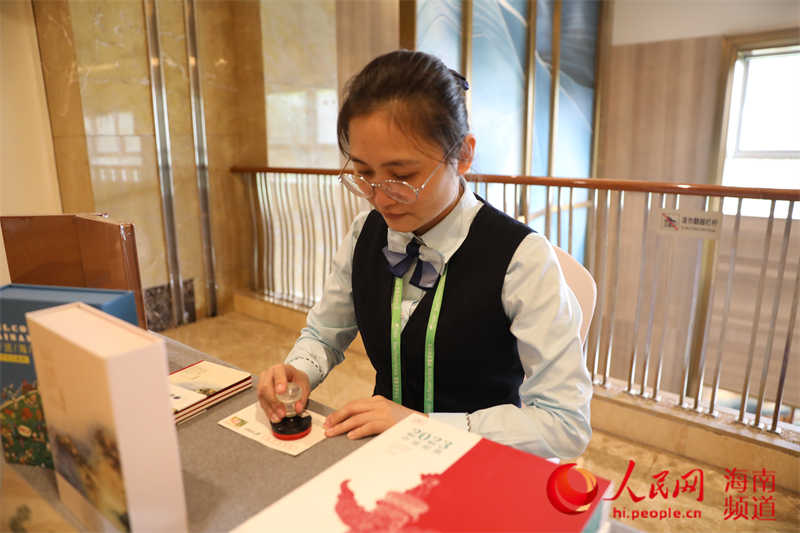 符新澄在為郵品加蓋紀念郵戳。人民網(wǎng)記者 孟凡盛攝