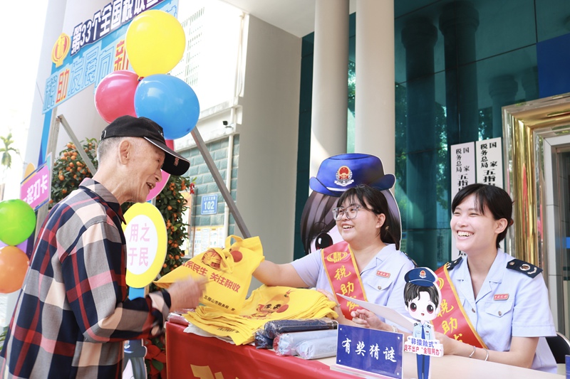 4.圖說：稅務(wù)干部為群眾送上猜謎稅宣獎(jiǎng)品，群眾拿到獎(jiǎng)品喜笑顏開。攝影者：張秋瑾