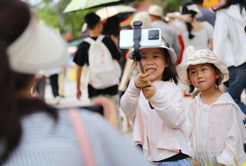 5月3日，家長(zhǎng)帶著孩子在三亞南山文化旅游區(qū)游覽。