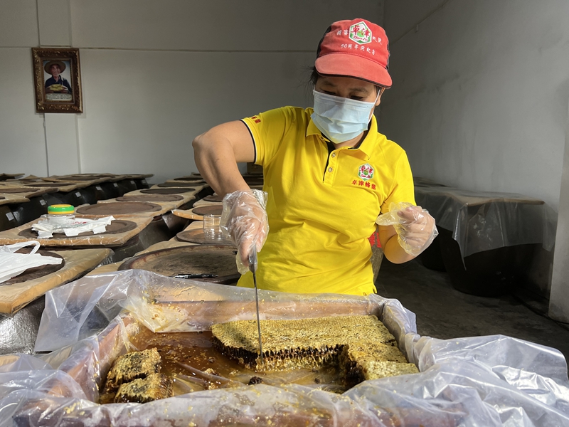 工作人員在切割蜂蜜。魏壽華攝