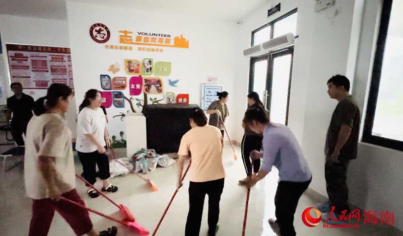 在文昌市龍樓鎮(zhèn)航天大社區(qū)安置點，大家齊心協(xié)力將水排出。人民網(wǎng)記者 符武平攝