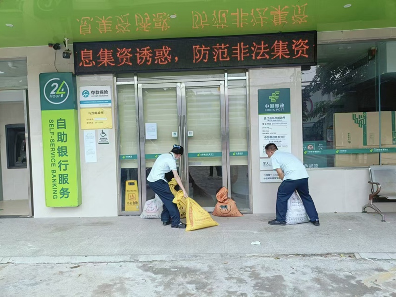 郵政人員在臺(tái)風(fēng)前做好網(wǎng)點(diǎn)防范工作。