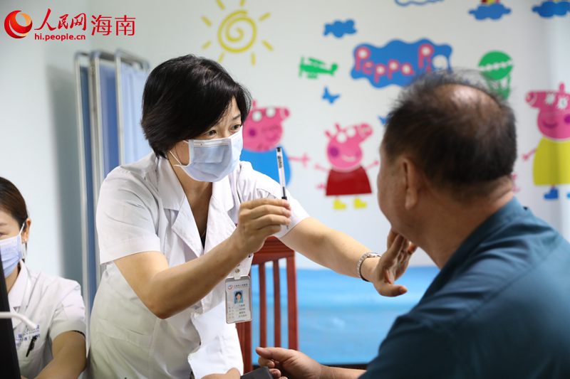 丁群芳（左）為患者看病。 人民網(wǎng)記者 孟凡盛攝