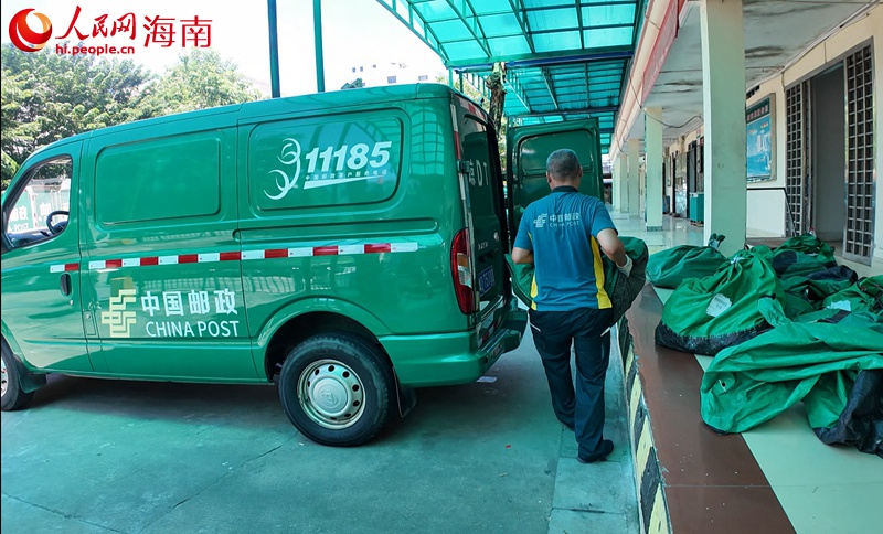 吳育仙將郵件搬運(yùn)裝車。人民網(wǎng)記者 李學(xué)山攝