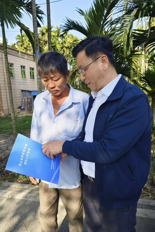 陳強拿著《防止返貧監(jiān)測對象幫扶工作指南》向檢測戶講解。抱古村供圖