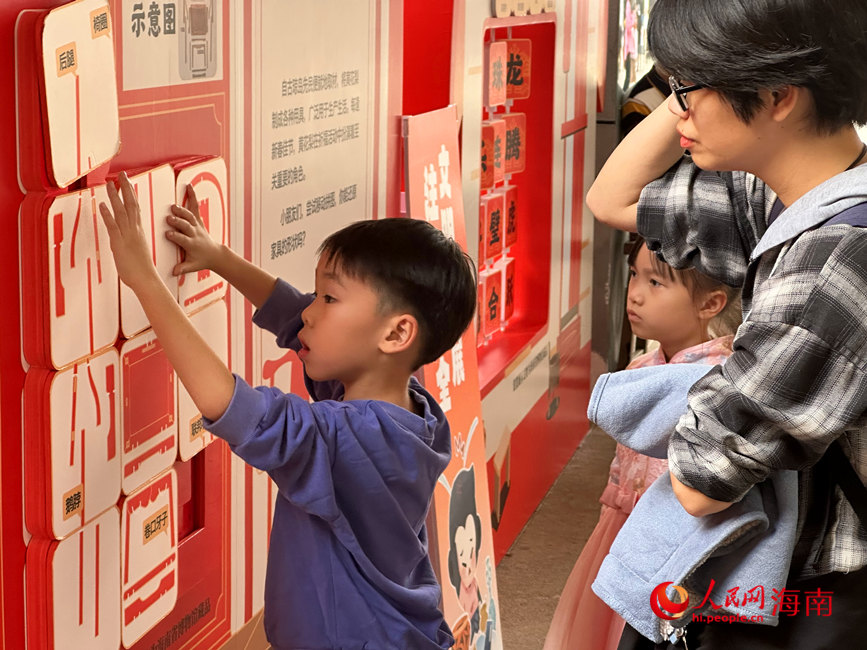 一名小朋友及其家人在海南省博物館舉辦的主題科普互動展中體驗“闖關”游戲。人民網(wǎng) 劉楊攝