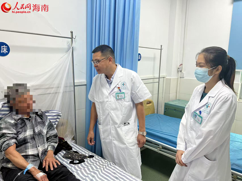 王秀權(quán)（中）在和患者交流。人民網(wǎng)記者 李學(xué)山攝