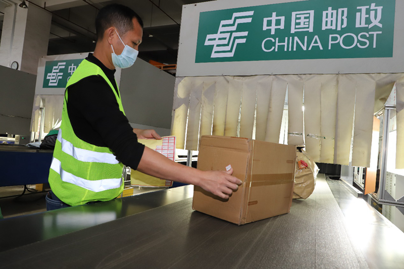 ?？卩]區(qū)中心工作人員逐件過機安檢合格的郵件粘貼 “已安檢” 標(biāo)識。黃文燕攝
