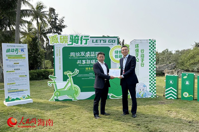中共海南省委外事工作委員會(huì)辦公室副主任王磊向瓊海市人民政府副市長(zhǎng)符展授予“碳匯捐贈(zèng)感謝狀”。人民網(wǎng)記者 符武平攝