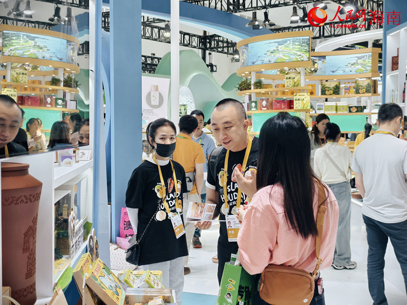 工作人員在向游客講解產(chǎn)品。人民網(wǎng) 符澤民攝