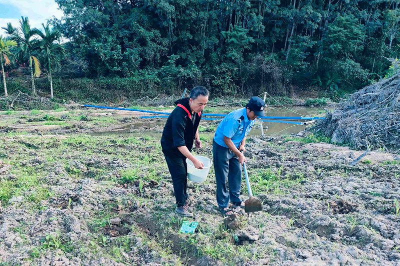 范平釗（左一）幫助農(nóng)戶鋤地。育才生態(tài)區(qū)馬腳村委會(huì)供圖.jpg