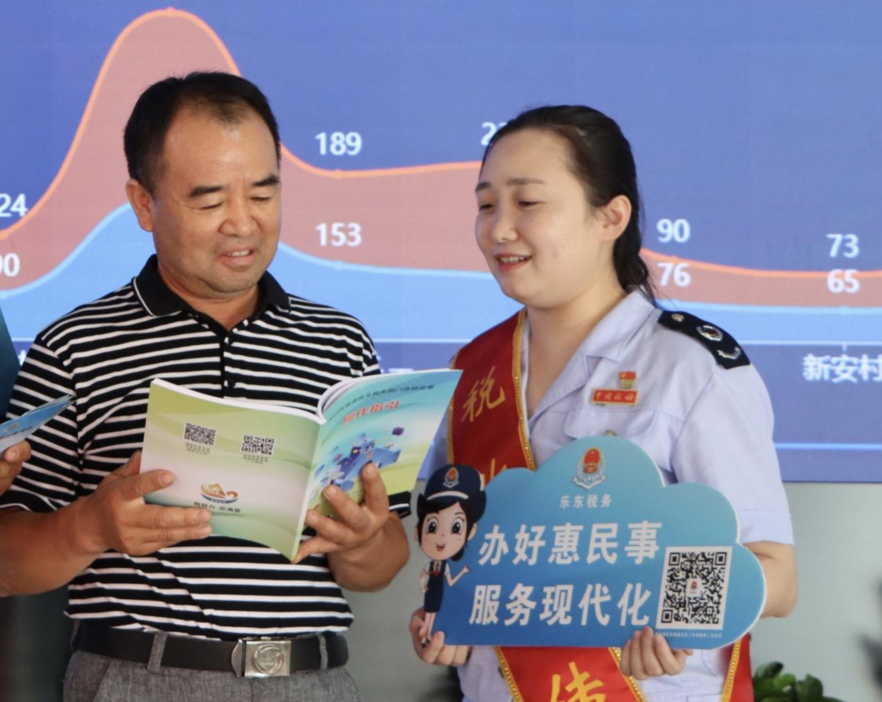 吳佳蔚在對(duì)納稅人進(jìn)行稅費(fèi)政策輔導(dǎo)。潘瑩攝