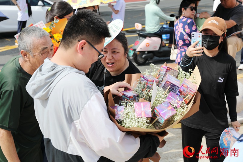 學(xué)生走出考場，家長為考生送上“盲盒鮮花”。人民網(wǎng)記者 符武平攝