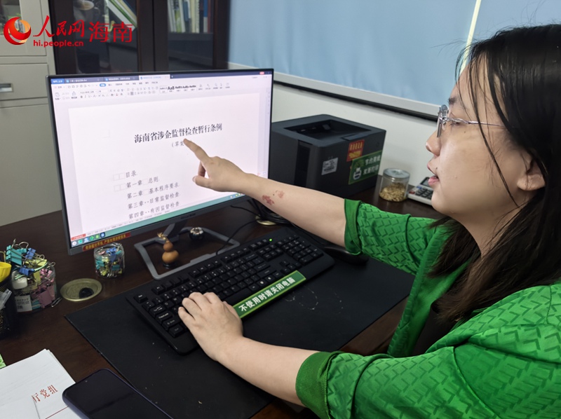 馮譯向記者展示海南優(yōu)化營商環(huán)境的最新成果。人民網(wǎng)記者 毛雷攝