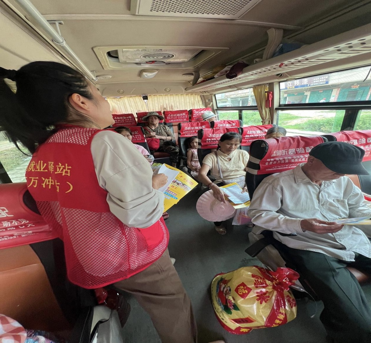 驛站工作人員在大巴車上為村民介紹招聘崗位。萬(wàn)沖就業(yè)驛站供圖