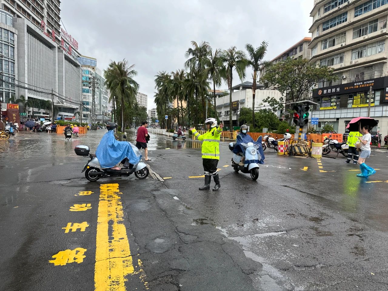 7月20日，交警龍華大隊警力在龍華路積水路口疏導(dǎo)，勸導(dǎo)車輛繞行遠離積水區(qū)域。 海口公安交警供圖