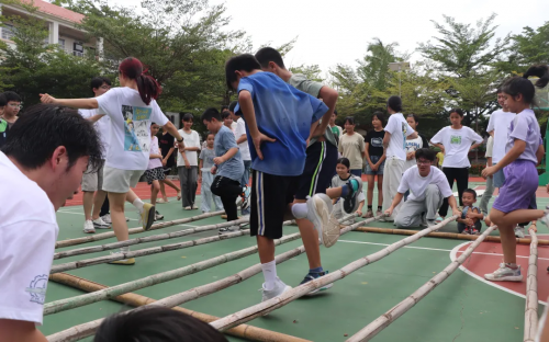 哈工大師生與檳榔村小朋友共跳竹竿舞。主辦方供圖